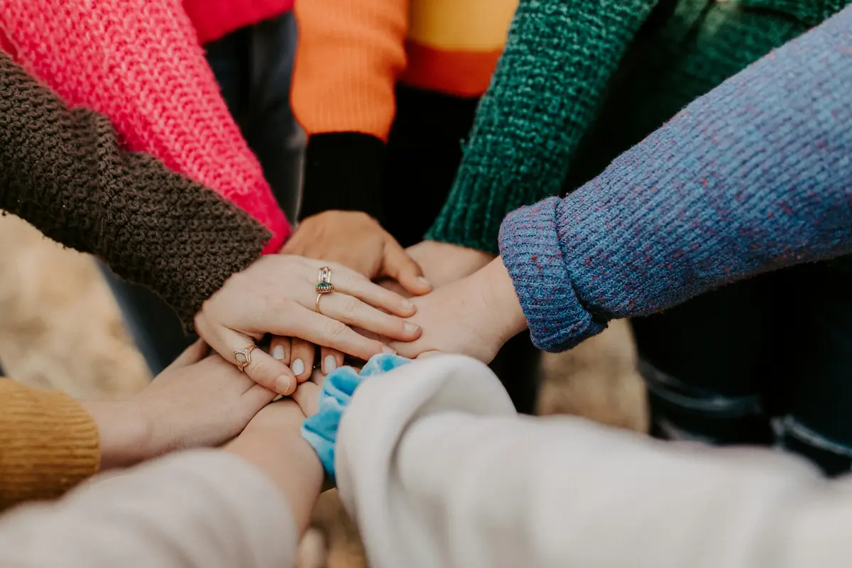 Photo of hands in a circle representing teamwork